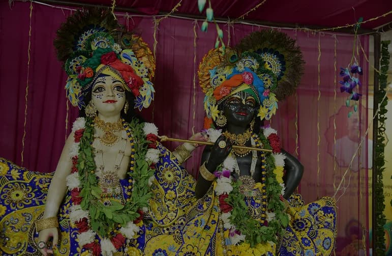 Deities adorned with flower garlands and peacock-feather crowns