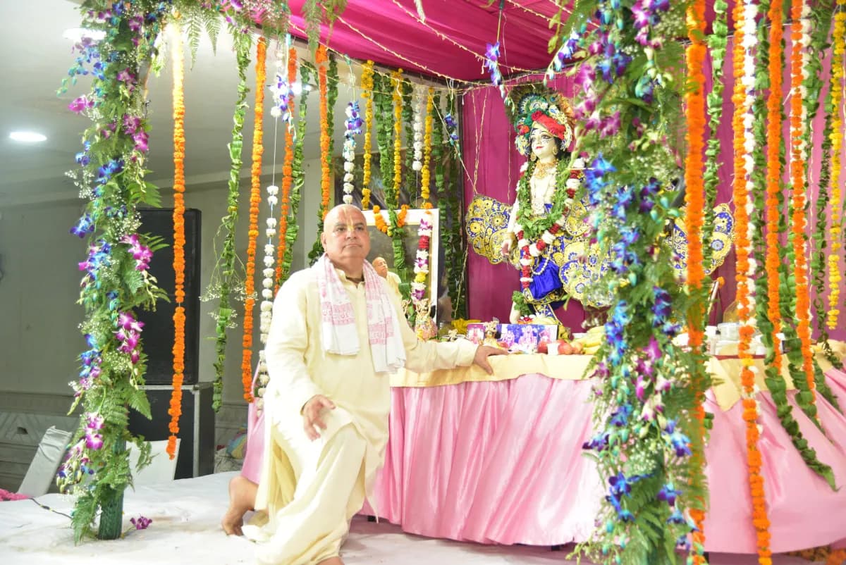 A devotee seated before the flower-decorated altar