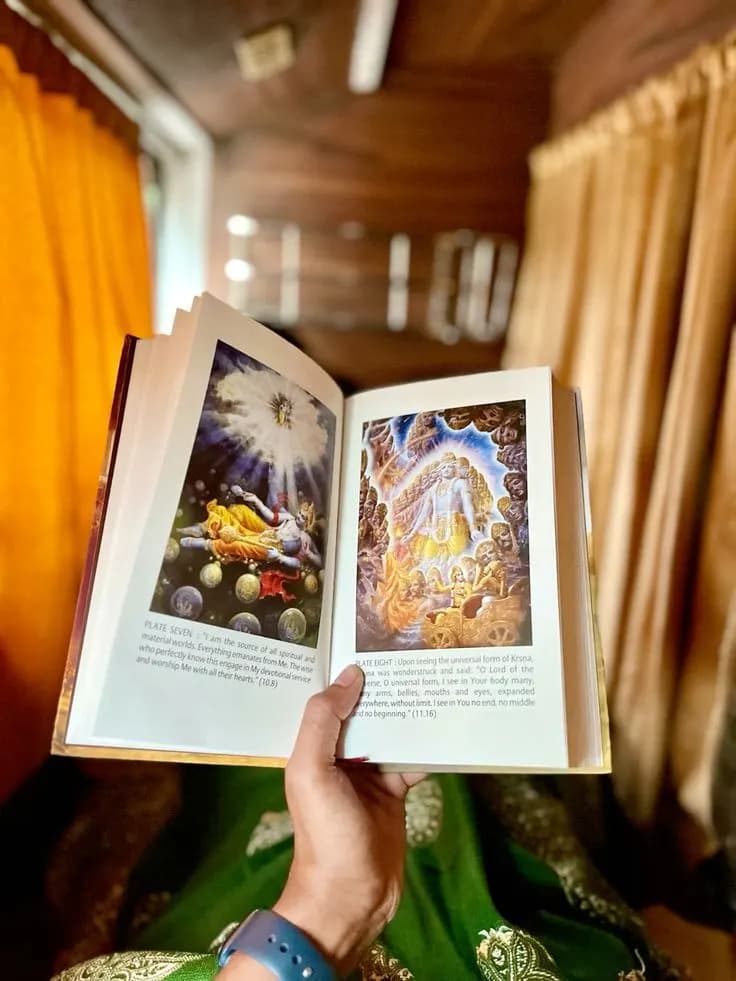 An open Bhagavad Gita As It Is, showing its colour plates