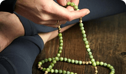 Hands chanting on japa meditation beads