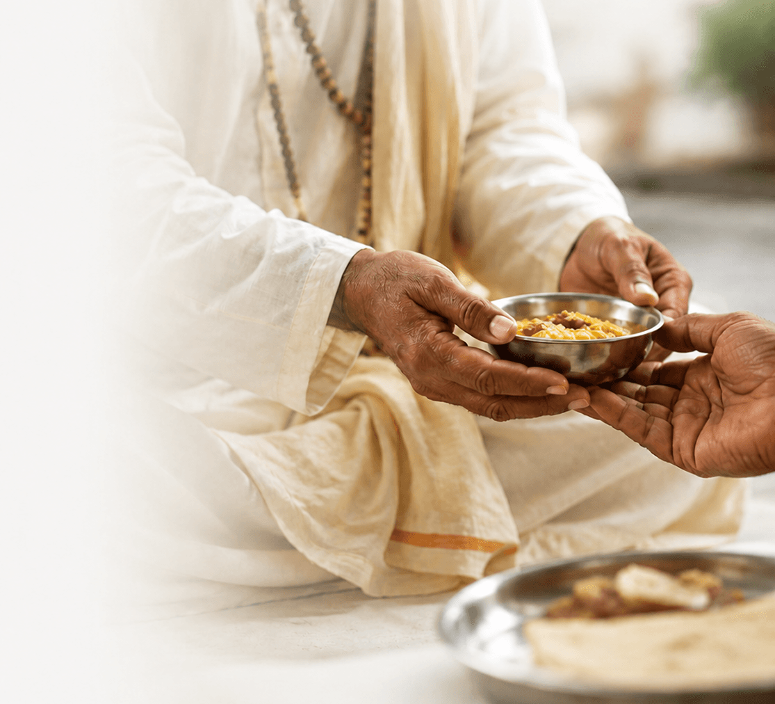 A sadhu receiving a bowl of prasadam with both hands