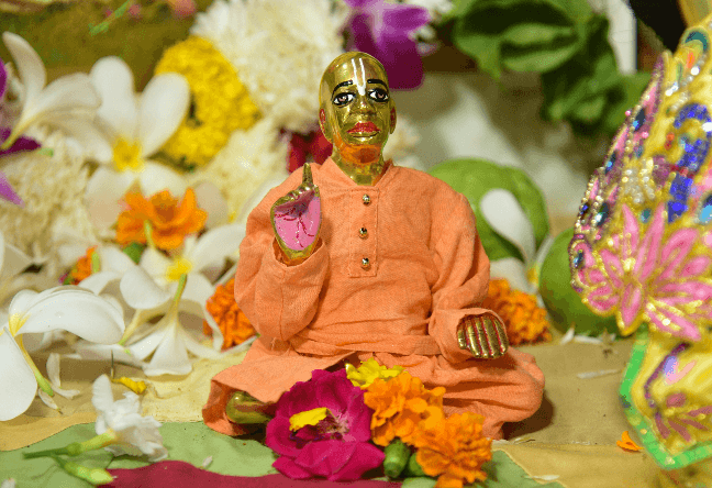 Murti of Srila Prabhupada adorned with fresh flowers