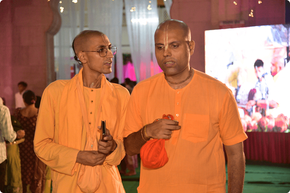 Two sadhus in saffron robes in conversation at the temple